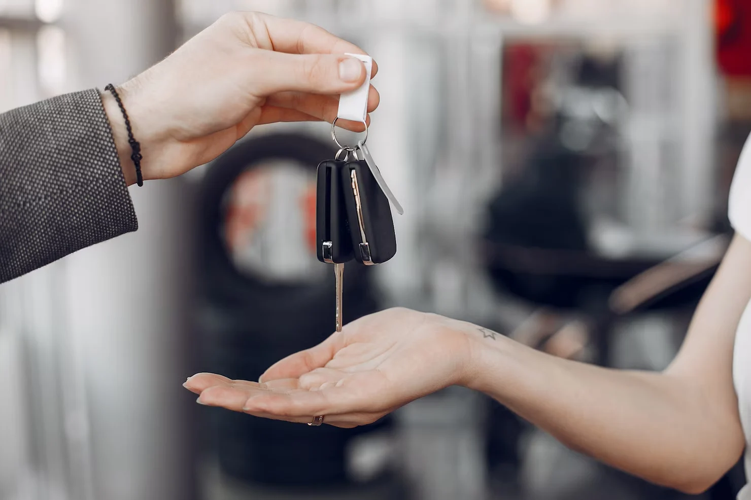 Car keys being handed over symbolizing getting the lowest auto loan interest rate