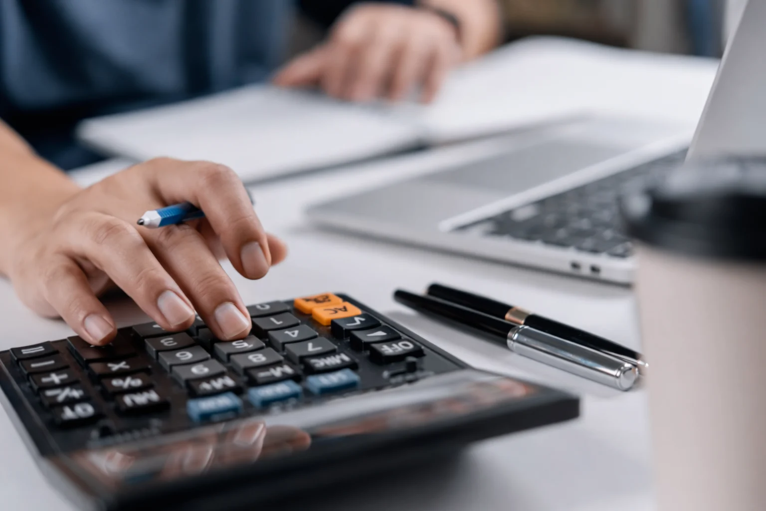 Person using calculator to plan debt payoff strategy such as avalanche or snowball method